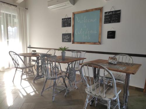 a dining room with tables and chairs and a chalkboard at Caledonia B&B in Mercato San Severino