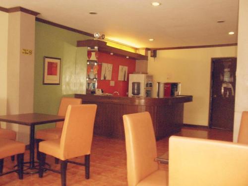 a dining room with a table and chairs and a kitchen at Mo2 Days Inn in Taculing Hacienda