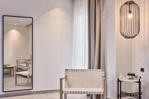 a room with a mirror and a chair and a table at Atlantica Marmari Palace in Mastichari