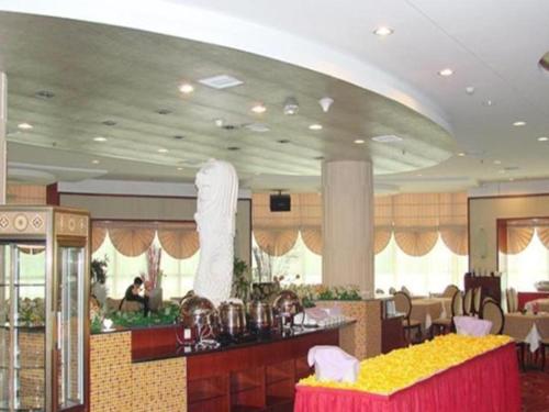un ristorante con bar con tavoli gialli e rosa di Zhangzhou Longhai Diamond Hotel a Longhai