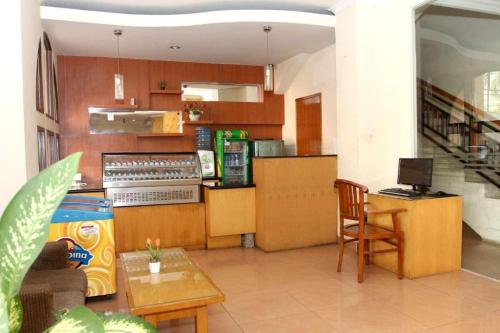 a kitchen with a counter and a table and chairs at Hotel Grande Lampung in Lampung