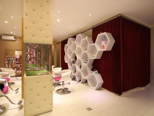 a salon with white chairs and a staircase in a store at Griya Jogja Hotel in Yogyakarta