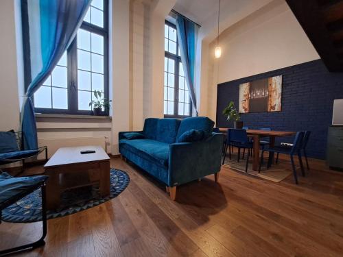 a living room with a blue couch and a table at RedCity LOFT 430 in Żyrardów