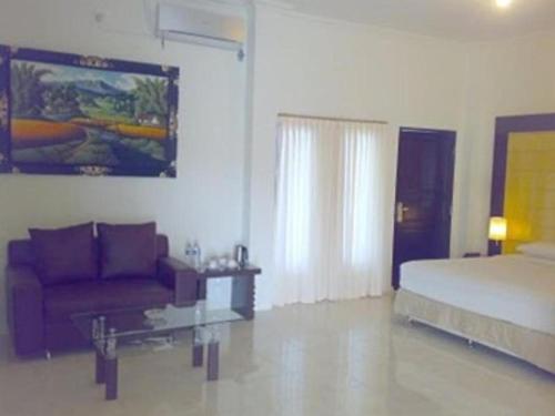 a bedroom with a bed and a couch at Grand Wisata Hotel in Ende