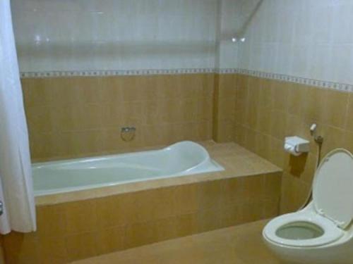 a bathroom with a bath tub and a toilet at Grand Wisata Hotel in Ende