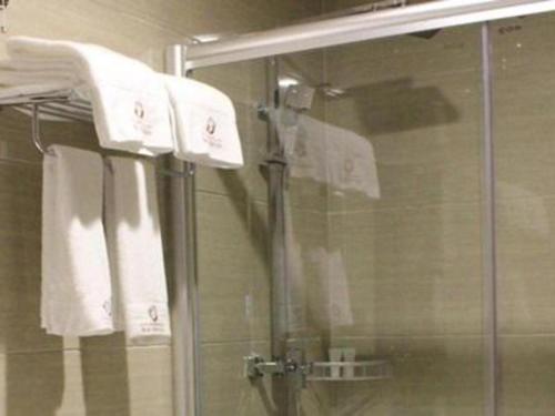 een douche met witte handdoeken in de badkamer bij Guangyuan Hotel Gutian Fujian 