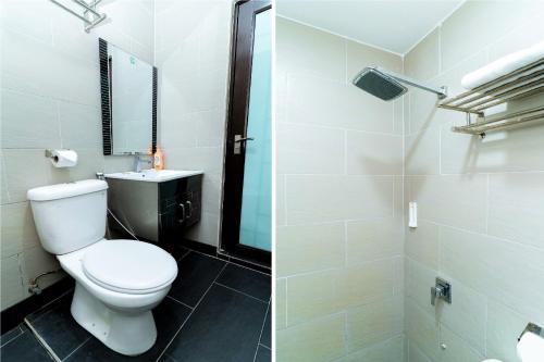 a bathroom with a white toilet and a shower at OYO 90375 Reggae Inn in Bintulu