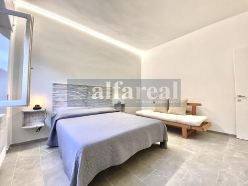 1 dormitorio con cama y banco. en Elicriso a pochi passi da spiaggia e dal centro! by Alfareal, en Castiglione della Pescaia