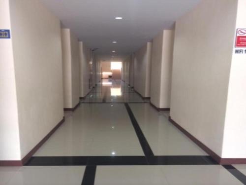 un corridoio di un edificio con pareti bianche e pavimento malandato di V.R.Mansion Hotel a Phatthalung