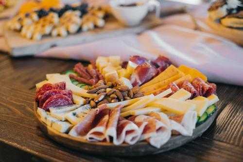a plate of cheese and other foods on a table at Talići Hill - Rustic Villas in Sutomore