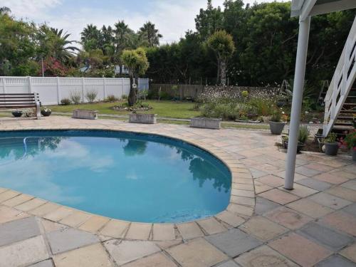 a swimming pool in a yard with a bench at Ria's Rest Self Catering Flatlet in Sedgefield