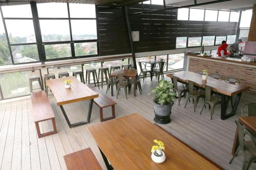 an empty restaurant with wooden tables and chairs at Citihub Hotel @Jagoan Magelang in Magelang