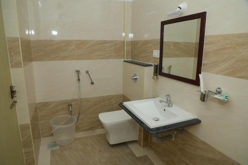 a bathroom with a sink and a toilet and a mirror at ANNAI RESIDENCY in Vellore