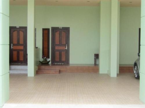 un pasillo con tres puertas y un coche en un edificio en Chodkamol Place 57, en Nakhon Si Thammarat
