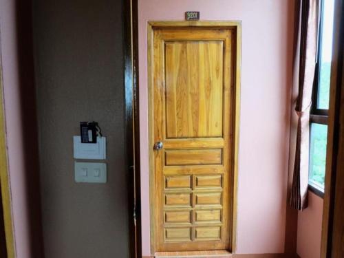 a wooden door in the corner of a room at Tai Asean House in Ban Kham Kling