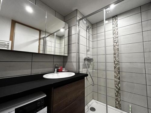 une salle de bain avec un lavabo et un miroir dans l'établissement Résidence Aravis - Appartement 6 pers ski au pied à la Croisette MAE-5444, aux Menuires