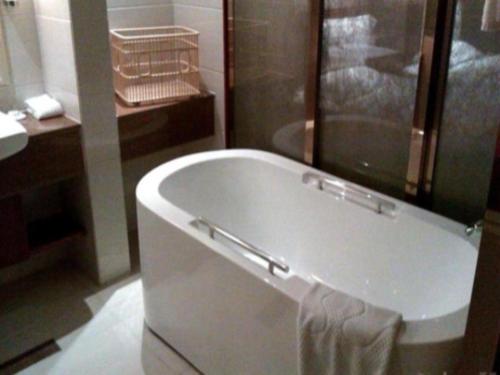 y baño con bañera y lavamanos. en Quanzhou Jinjiang Hollyston Hotel en Jinjiang
