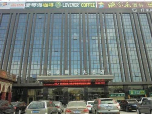 un grande edificio con macchine parcheggiate di fronte di Quanzhou Jinjiang Hollyston Hotel a Jinjiang