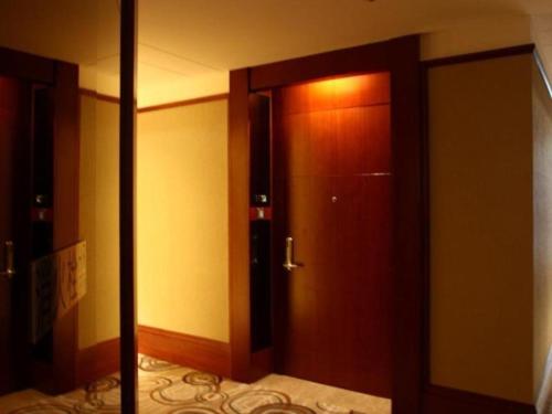 a wooden door in a room with a hallway at Quanzhou Jinjiang Hollyston Hotel in Jinjiang
