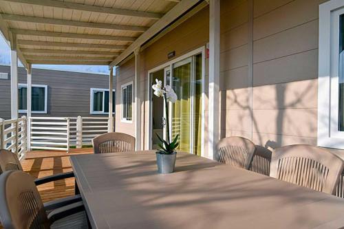 een tafel en stoelen op de veranda van een huis bij La Risacca Family Camping Village in Porto SantʼElpidio