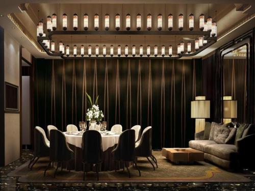 a dining room with a table and chairs and a couch at Southeast Peninsula Hotel Quanzhou in Quanzhou