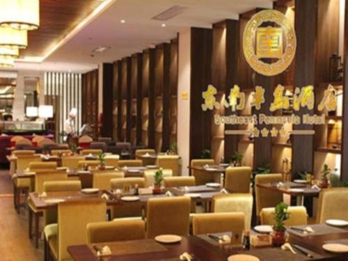 un restaurante con mesas y sillas y un cartel en la pared en Southeast Peninsula Hotel Quanzhou, en Quanzhou