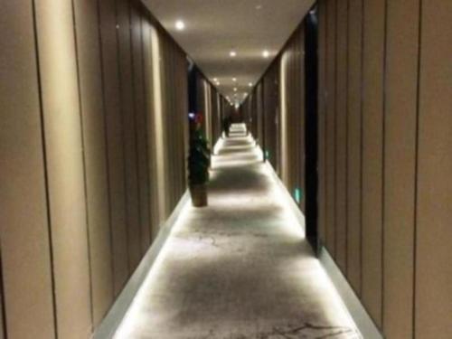 a long hallway of a building with a plant at Southeast Peninsula Hotel Quanzhou in Quanzhou
