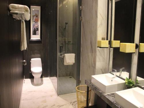 a bathroom with a shower and a toilet and a sink at Southeast Peninsula Hotel Quanzhou in Quanzhou