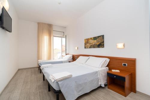 um quarto de hospital com duas camas e uma televisão em Hotel La Sirenetta em Tortoreto Lido