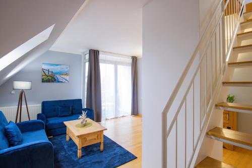 a living room with a blue couch and a table at Inselhotel kleiner Bodden in Buschvitz