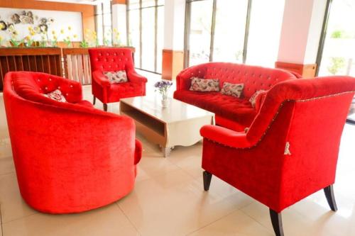a living room with two red chairs and a table at Hotel Mekkah Banda Aceh in Banda Aceh