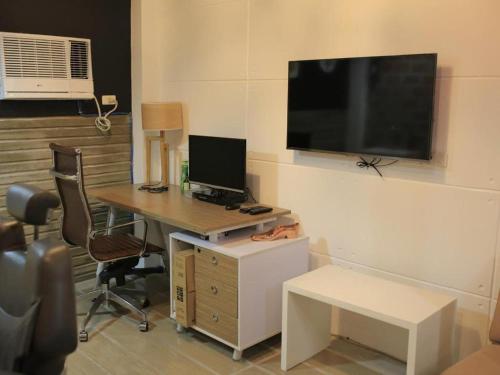a room with a desk with a computer and a tv at Hotel Monde in Dagupan