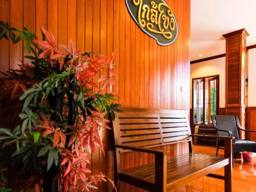 a wooden wall with a bench and a plant at Ban Glai Kong in Chiang Khan