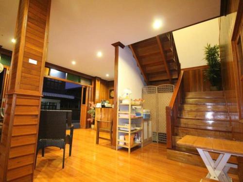 ein Wohnzimmer mit einer Treppe, einem Tisch und Stühlen in der Unterkunft Ban Glai Kong in Chiang Khan