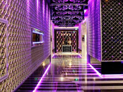 a hallway with purple lights on a wall at Fuzhou Fuqing Ruixin Hotel in Fuzhou