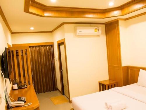 um quarto com uma cama e uma secretária com um telefone em Loei Residence em Ban Tha Phae