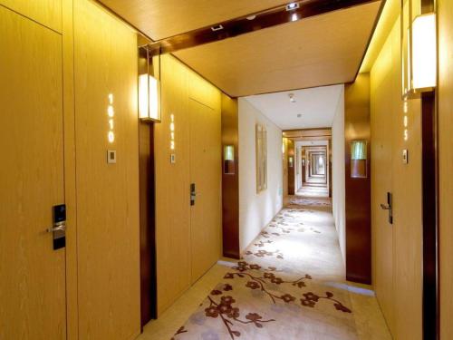 a hallway with yellow walls and a hallway with wooden doors at Xian Elegant Oriental Hotel in Xi'an