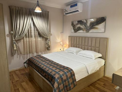 a bedroom with a large bed and a window at شقق روز الفندقية دخول ذاتي in Al Khobar