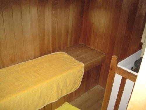 IsaにあるHotel Kaijyokanのベッド付きの小さな木造キャビン