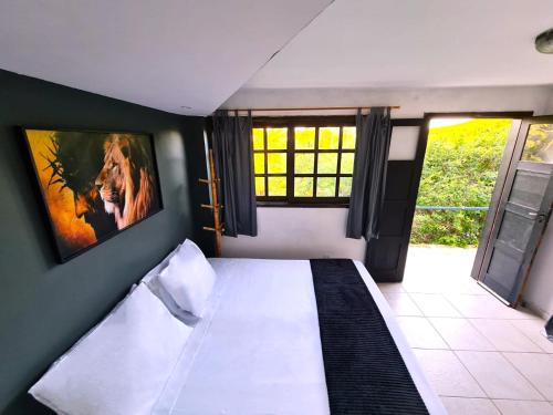 a bedroom with a bed with a picture on the wall at Shanti Life in Búzios