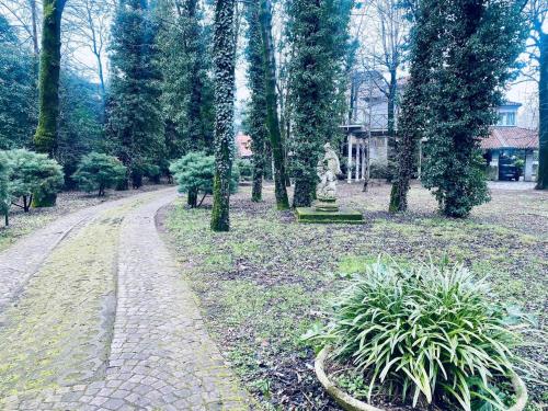 un camino en un parque con una estatua y árboles en la casa dei nonni, en Leinì