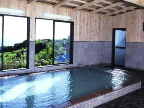 IsaにあるAshizuri Onsen Ashizuri Sunnyside Hotelの窓付きの客室内のスイミングプールを利用できます。