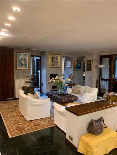 sala de estar con sofás blancos y chimenea en la casa dei nonni over 65 en Leinì