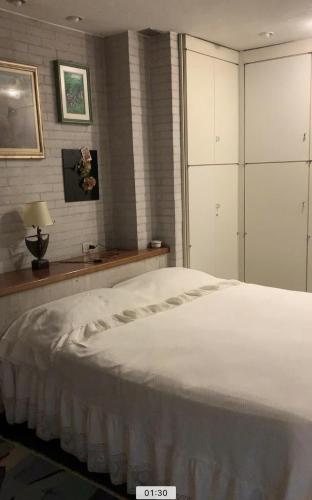 1 dormitorio con 1 cama blanca grande y vestidor en la casa dei nonni, en Leinì