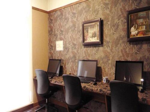 uma sala com uma secretária com quatro computadores em Toyooka Green Hotel Morris em Toyooka