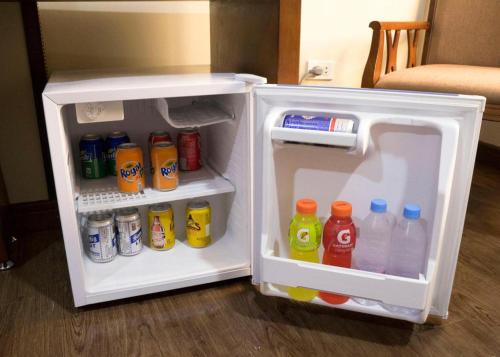 an open refrigerator filled with drinks and soda at Horizon Hotel in Olongapo