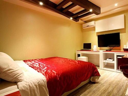 1 dormitorio con 1 cama con manta roja en Asan ING Hotel en Asan