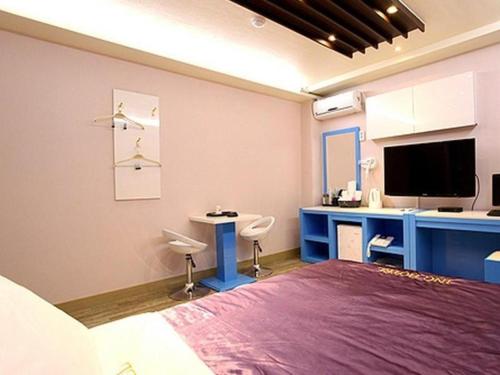 1 dormitorio con 1 cama, escritorio y TV en Asan ING Hotel en Asan