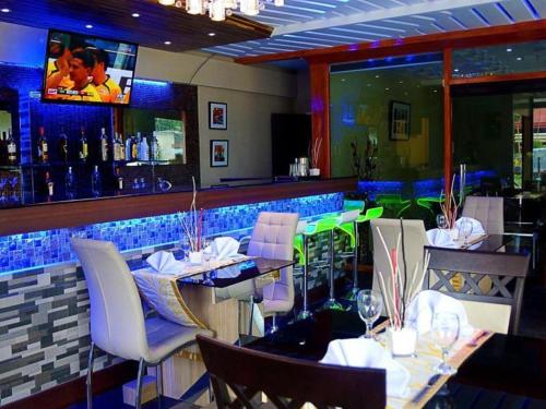un restaurante con un bar con mesas y sillas en Zanrock Micro Hotel en Lagao III