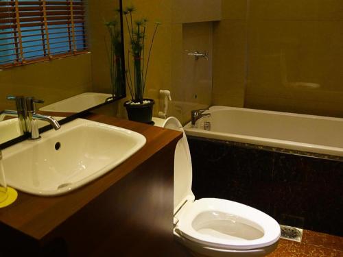 a bathroom with a sink and a toilet and a tub at Zanrock Micro Hotel in Lagao III